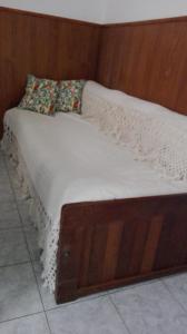 una cama de madera con 2 almohadas encima en Roberta en Bahía Blanca
