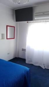 Un dormitorio con una cama azul y una ventana en Roberta en Bahía Blanca