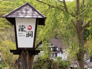 水上町鲁宇尤多酒店的树上的一个标志,有房子的背景