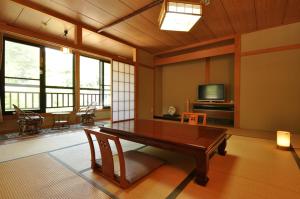 a living room with a table and a tv at Ryuudo in Minakami