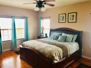 a bedroom with a bed with blue curtains and a ceiling fan at Rockwood Condos on Table Rock Lake With Boat Slips in Branson +93 photos
