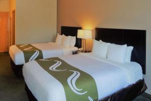 a hotel room with two beds with white sheets at Quality Inn Tulalip - Marysville in Marysville