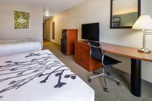 a hotel room with a desk and a bed at Sleep Inn & Suites in Rapid City