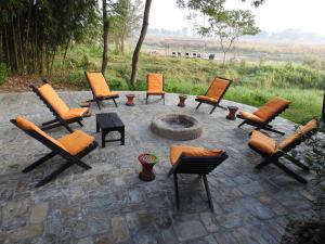 a group of chairs sitting around a fire pit at Sapana Village Lodge in Sauraha