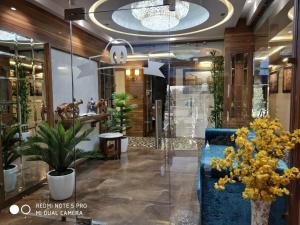 阿姆利则Hotel Makhan Residency的大堂设有蓝色的沙发和一些植物