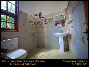uma casa de banho com um lavatório e um WC em Heaven Upon Rice Fields em Anuradhapura