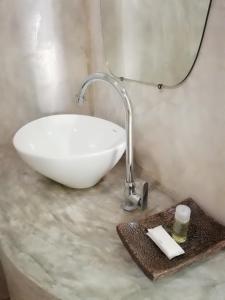 a bathroom with a white sink and a mirror at Wanlapa Farmstay in Ban Khok Krathiam