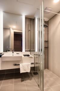 een badkamer met een wastafel en een douche bij Golden Tulip Incheon Airport Hotel in Incheon