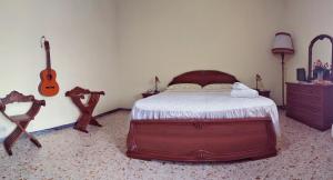 a bedroom with a bed with a guitar and a suitcase at Civico 13 in Camposano