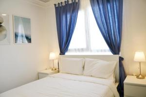 a bedroom with a bed and a window with blue curtains at 151 in Kuwait