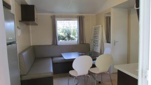 een kleine keuken met een tafel en stoelen. bij Mobil Home 3 ch in Saint-Georges-de-Didonne