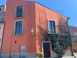 an orange building with ivy on the side of it at Casa del 1000 Alloggio locato per fini turistici in Canino