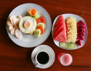 uma mesa com dois pratos de comida e uma chávena de café em Bali Rahayu Homestay em Munduk