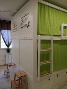 um quarto com um beliche com cortinas verdes em Albergue La Magia del Camino em Comillas