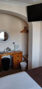 - une chambre avec un lavabo et une table en bois dans l'établissement Penryn Guest House, ensuite rooms, free parking and free wifi, à Stratford-upon-Avon