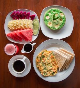 une table avec trois assiettes de nourriture et une tasse de café dans l'établissement Bali Rahayu Homestay, à Munduk