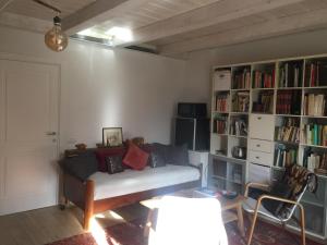 uma sala de estar com um sofá e prateleiras de livros em Agriturismo Montedago em Ancona