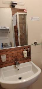 uma casa de banho com um lavatório branco e um espelho. em Penryn Guest House, ensuite rooms, free parking and free wifi em Stratford-upon-Avon