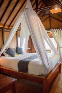 a bedroom with a bed with a mosquito net at Bali Rahayu Homestay in Munduk