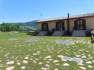 a house with a grass yard in front of a building at Agriturismo Rocca del Nera in Preci