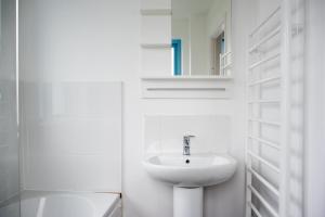 a white bathroom with a sink and a mirror at Pebbles in Lyme Regis