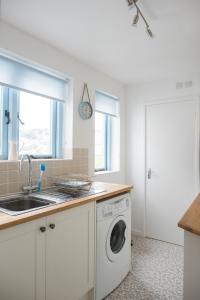 eine Küche mit Waschmaschine und Spüle in der Unterkunft Pebbles in Lyme Regis