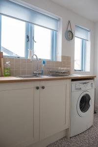 eine Küche mit Spüle und Waschmaschine in der Unterkunft Pebbles in Lyme Regis