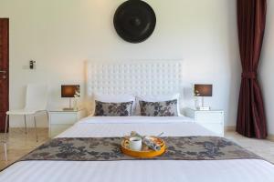 a bedroom with a bed with a bowl of food on it at Baan Siri Varee in Mae Nam