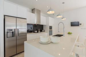 a white kitchen with a large white counter top at Baan Siri Varee in Mae Nam