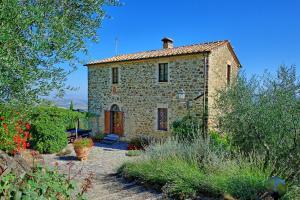 an old stone house with a garden in front of it at Tenuta Canina in Montalcino