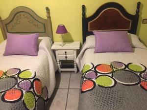 sypialnia z dwoma łóżkami i stołem z lampą w obiekcie Apartamento Turistico Luar 1 w mieście El Rasillo