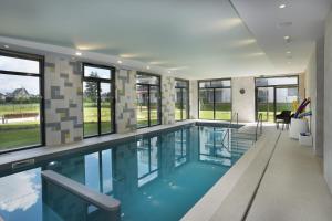 een zwembad in een huis met ramen bij Domitys L'organdi in Kingersheim