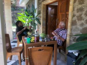 an older man sitting at a table in a room at Marie'z Villa in Tuktuk Siadong