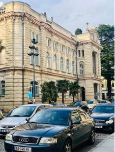 a car parked in front of a large building at Hostel City Center in Kutaisi