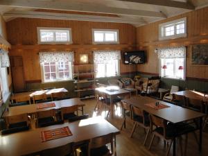 a dining room with tables and chairs and windows at Sunne Hembygdsgård B&B in Sunne