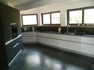a kitchen with black and white counters and windows at VILLA KB'HOME in Le Touquet-Paris-Plage