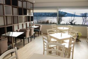 a restaurant with tables and chairs and a large window at Paralimnio Suites in Kastoria