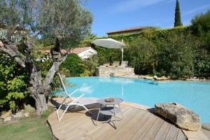 una terraza con una silla y una mesa junto a la piscina en Au pays de Cézanne Picasso & Matisse, en Aix-en-Provence
