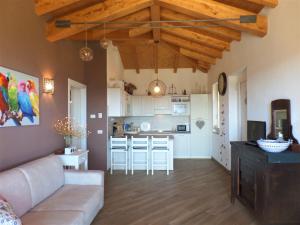 a living room with a couch and a kitchen at La Briciola in Lesa