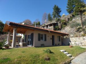 a small house with a stone wall at La Briciola in Lesa