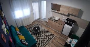 Il comprend une petite cuisine et un salon avec un canapé bleu. dans l'établissement Home away from home, à Novi Sad