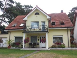 a yellow house with a balcony and a patio at Muszla in Pobierowo