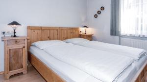 una camera da letto con un grande letto con lenzuola bianche di Appartements Respiration Almhaus Pfister a Predoi