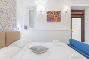 ein weißes Schlafzimmer mit einem Bett und einem Gemälde in der Unterkunft Dolce Vita New Studio in Rom