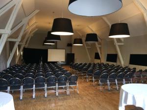 una stanza vuota con sedie, tavoli e luci di Hôtel Château de Lacan a Brive-la-Gaillarde