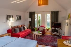 ein Wohnzimmer mit einem roten Sofa und einem TV in der Unterkunft Apartment Haak in Halle Westfalen