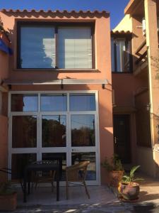 a glass door with a table in front of a house at Veranda Sopra di Cala d'Ambra e Ogliastra in San Teodoro