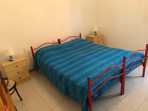 a bedroom with a bed with a blue striped blanket at Villa Brigida in Manduria +69 photos