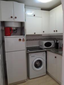 małą kuchnię z białymi szafkami i pralką w obiekcie Apartment Manuel Galián 52 w mieście Torrevieja