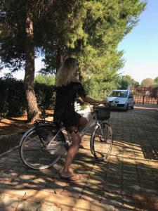 a woman in a dress riding a bike at Villa Brigida in Manduria